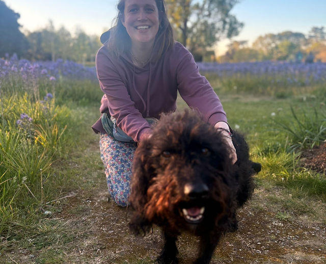 Livvy with a black shaggy dog in a field
